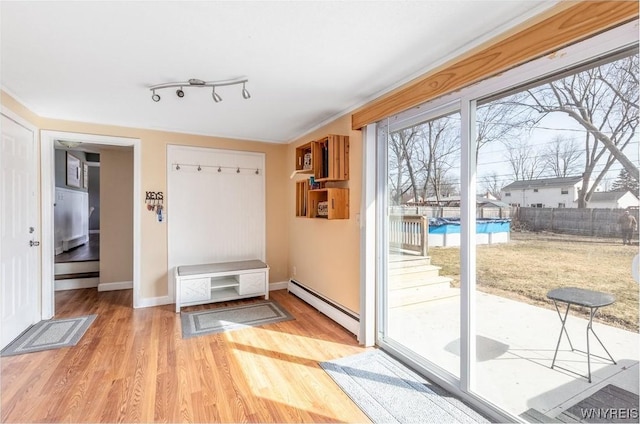 entryway with a baseboard radiator, baseboards, and wood finished floors