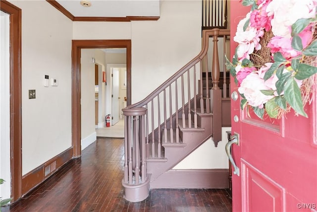 foyer with stairs, crown molding, hardwood / wood-style flooring, and baseboards