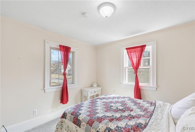 bedroom featuring a textured ceiling, baseboards, crown molding, and carpet