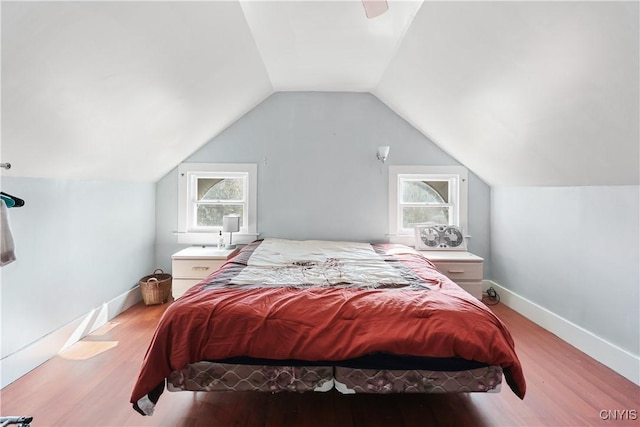 bedroom with lofted ceiling, wood finished floors, and baseboards