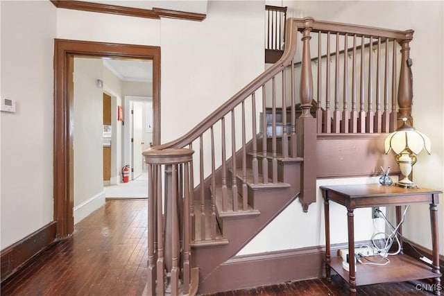 stairway featuring crown molding, baseboards, and hardwood / wood-style flooring