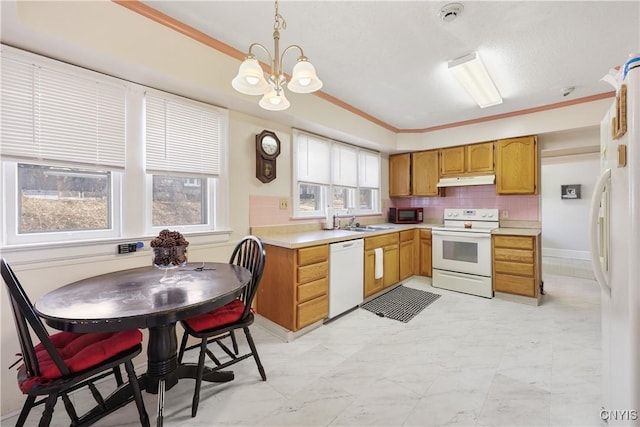 kitchen with white appliances, plenty of natural light, a chandelier, and light countertops