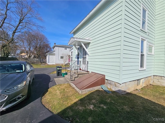 view of side of home with a yard