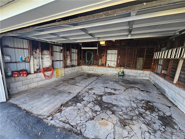 garage featuring a garage door opener and concrete block wall