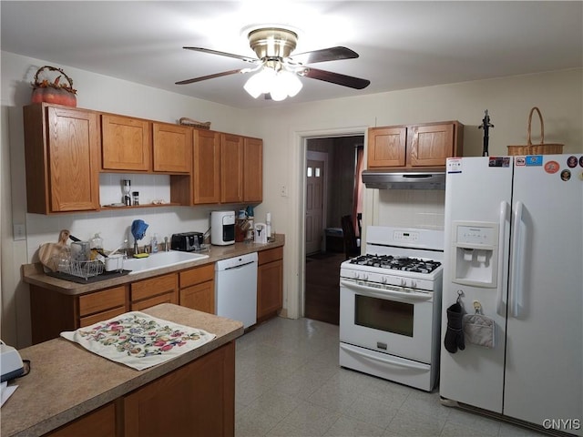 kitchen featuring brown cabinets, a ceiling fan, under cabinet range hood, white appliances, and light floors