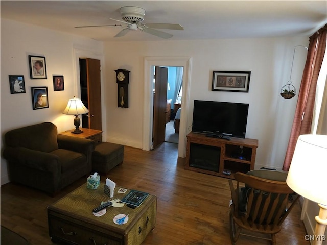 living room featuring baseboards, wood finished floors, and a ceiling fan