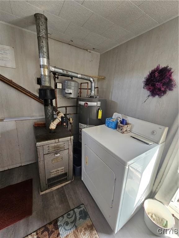 laundry room featuring water heater, a heating unit, washer / clothes dryer, and wood finished floors