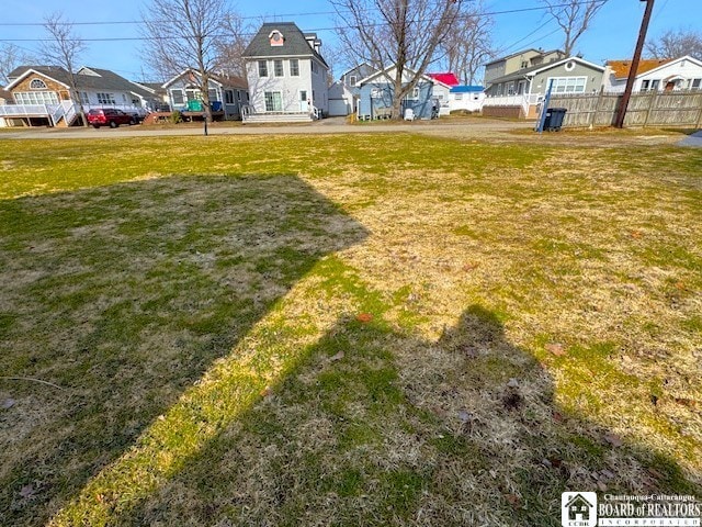 view of yard featuring fence and a residential view