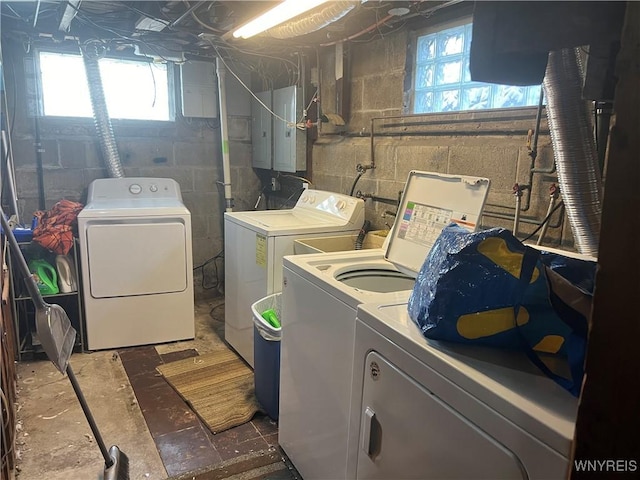 clothes washing area with laundry area, electric panel, plenty of natural light, and washing machine and clothes dryer