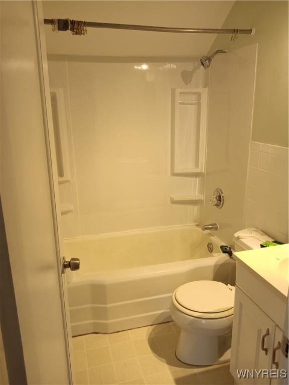 bathroom featuring vanity, bathing tub / shower combination, toilet, and tile walls