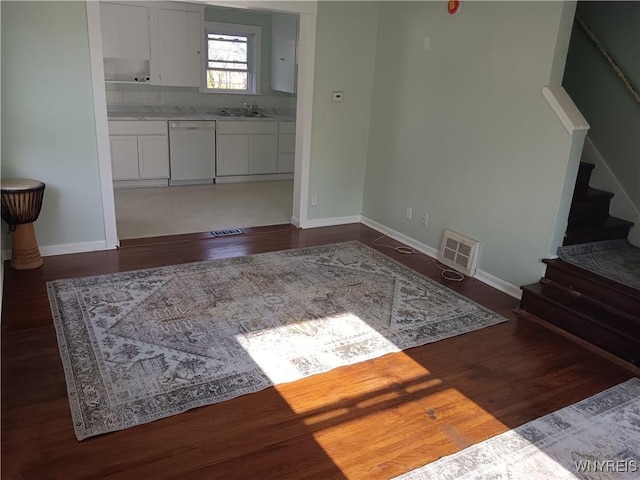 living area featuring visible vents, baseboards, dark wood-style floors, and stairway