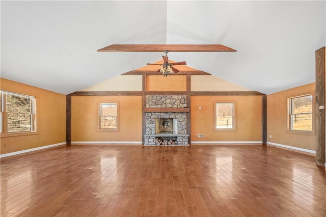 unfurnished living room with hardwood / wood-style flooring, lofted ceiling with beams, a ceiling fan, and baseboards