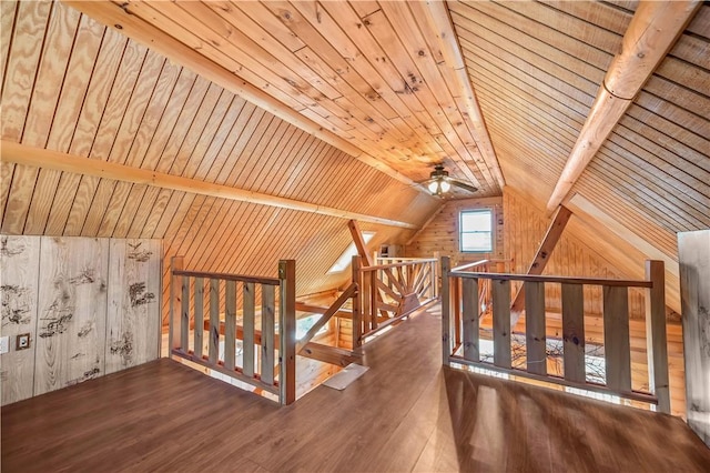 bonus room featuring wood finished floors, wooden walls, wooden ceiling, ceiling fan, and vaulted ceiling