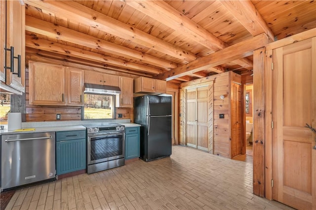 kitchen featuring blue cabinetry, stainless steel appliances, light countertops, under cabinet range hood, and beamed ceiling