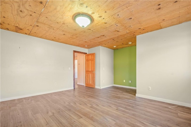 spare room with wood finished floors, wood ceiling, and baseboards