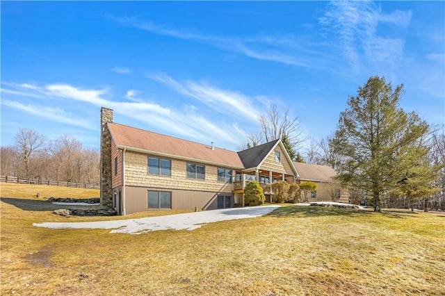 back of property featuring a chimney and a yard