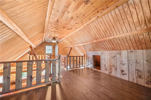 additional living space featuring ceiling fan, wood walls, vaulted ceiling, wooden ceiling, and wood finished floors