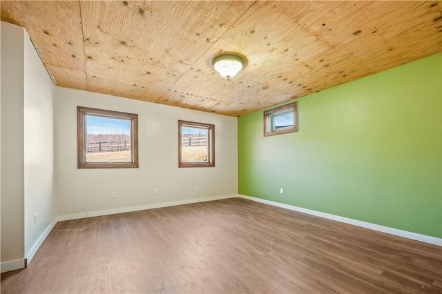 spare room with wood ceiling, baseboards, and wood finished floors