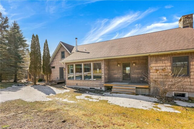 rear view of property with roof with shingles and a chimney