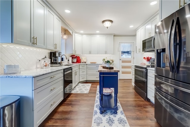 kitchen featuring a sink, stainless steel appliances, dark wood-type flooring, and butcher block countertops