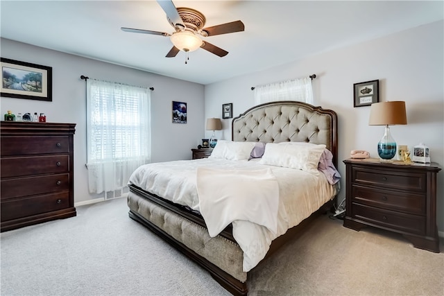 bedroom featuring light colored carpet and a ceiling fan