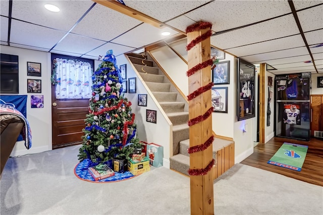 interior space featuring stairway, carpet floors, baseboards, and a drop ceiling