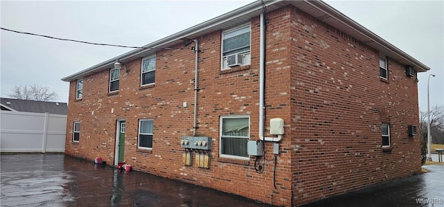 view of side of home with cooling unit and brick siding