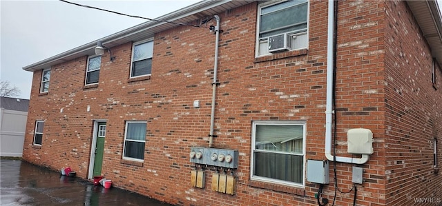 view of property exterior with cooling unit and brick siding