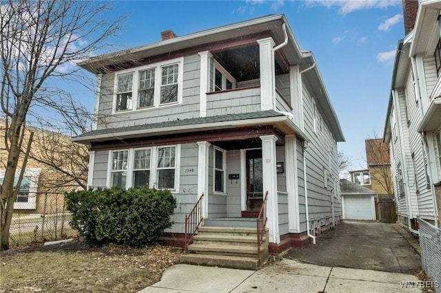 view of front of home with fence, a chimney, a balcony, an outdoor structure, and driveway