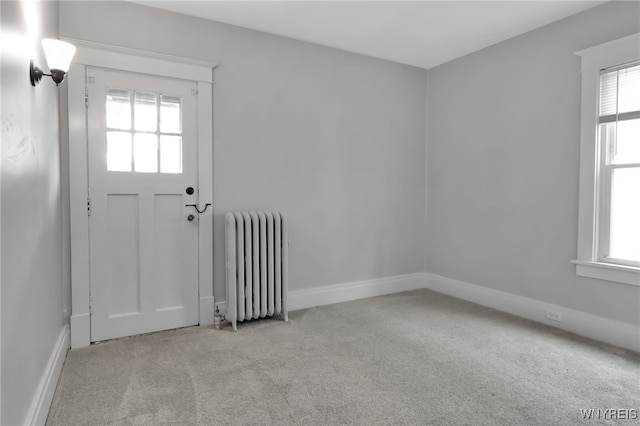 interior space with radiator heating unit, baseboards, and a wealth of natural light