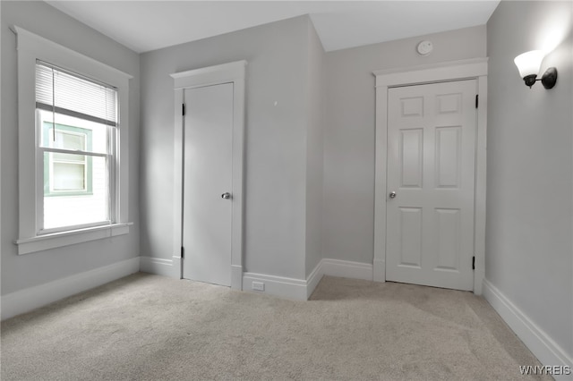 unfurnished bedroom with baseboards and carpet