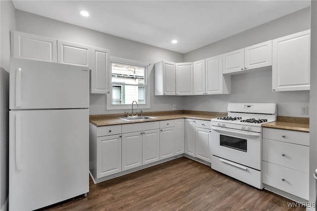 kitchen with dark wood-type flooring, recessed lighting, white cabinets, white appliances, and a sink