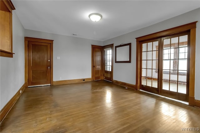 empty room with visible vents, baseboards, and wood finished floors