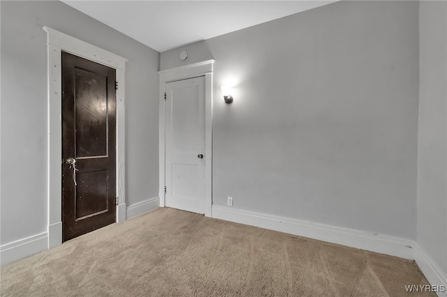 carpeted empty room featuring baseboards