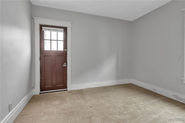 entrance foyer with light carpet and baseboards