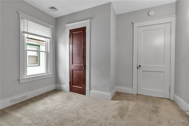 unfurnished bedroom featuring visible vents, baseboards, and carpet