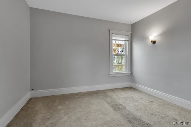 unfurnished room with carpet flooring and baseboards