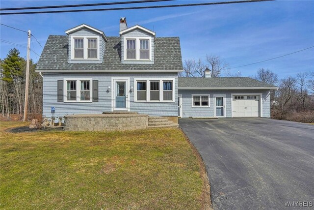 view of front of home featuring a front lawn, aphalt driveway, roof with shingles, a garage, and a chimney