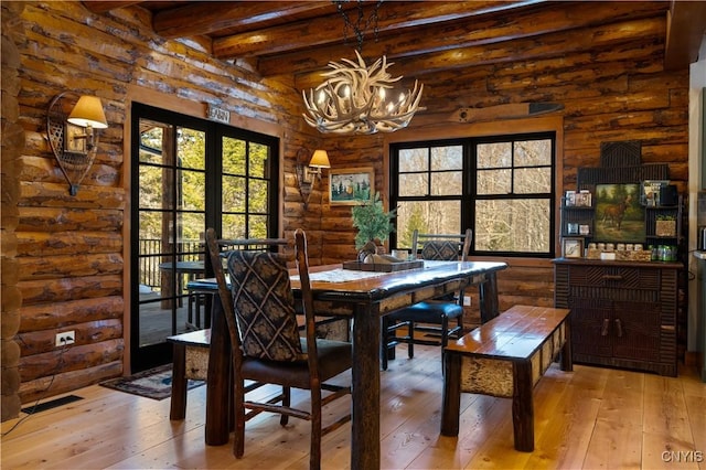 1392 Big Moose Rd, Webb, NY 13331 - dining room featuring hardwood / wood-style floors, a chandelier, log walls, beamed ceiling, and french doors