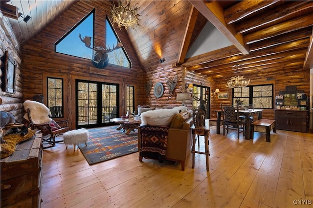 1392 Big Moose Rd, Webb, NY 13331 - living room featuring a chandelier, high vaulted ceiling, log walls, hardwood / wood-style floors, and beam ceiling