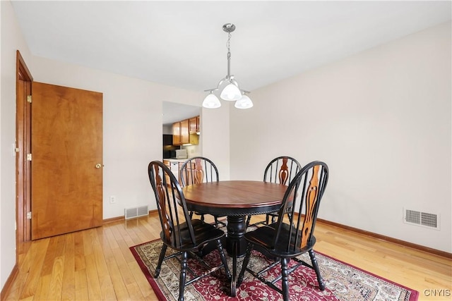 dining room featuring visible vents, baseboards, and light wood-style floors