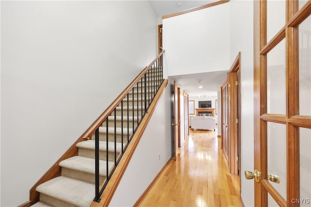 stairway with a towering ceiling and hardwood / wood-style flooring