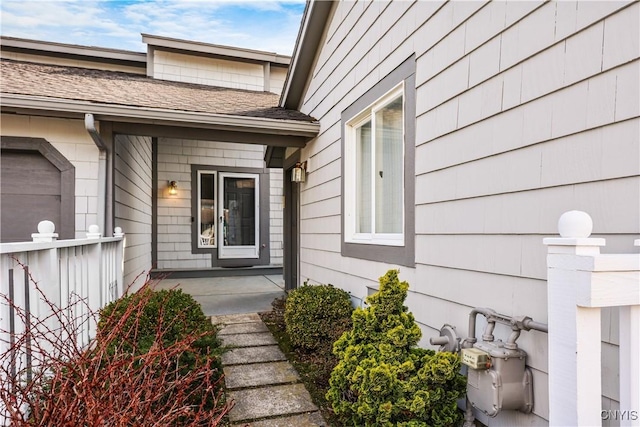 property entrance featuring a shingled roof