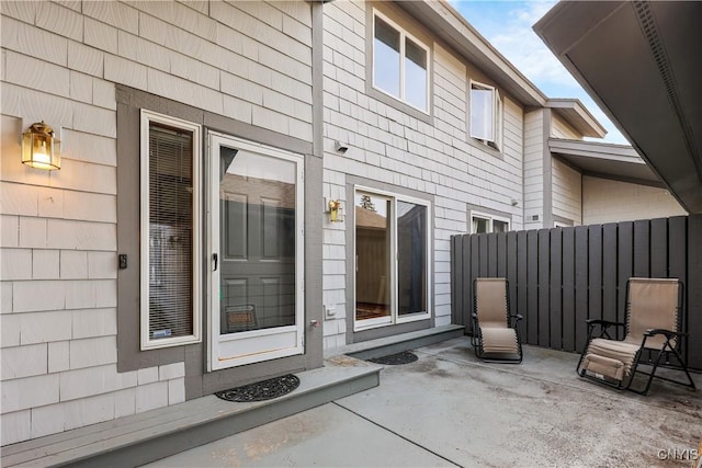 property entrance featuring a patio area and fence