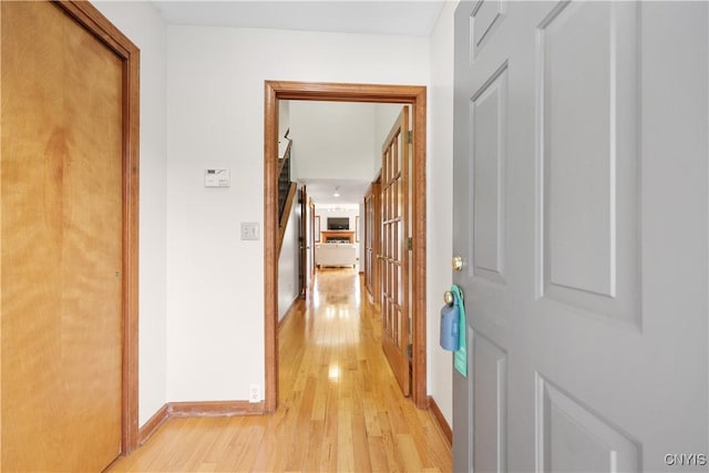 hall featuring baseboards and light wood finished floors