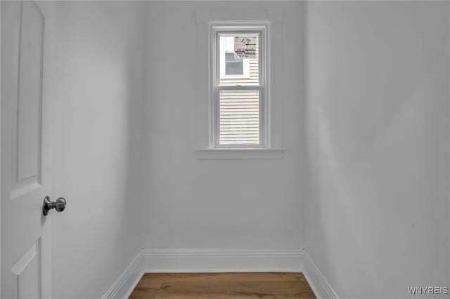 empty room featuring plenty of natural light, baseboards, and wood finished floors