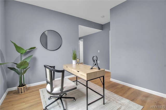 office area with baseboards and light wood finished floors