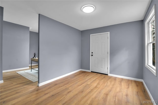 unfurnished room with light wood finished floors and baseboards