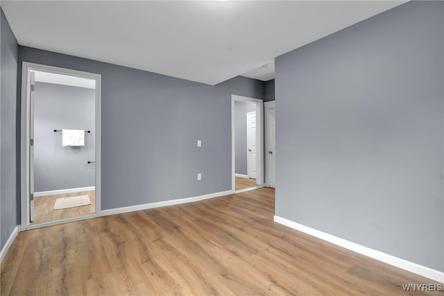 unfurnished room featuring baseboards and light wood-style floors