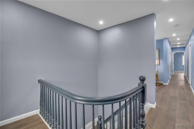 hall with an upstairs landing, recessed lighting, baseboards, and wood finished floors